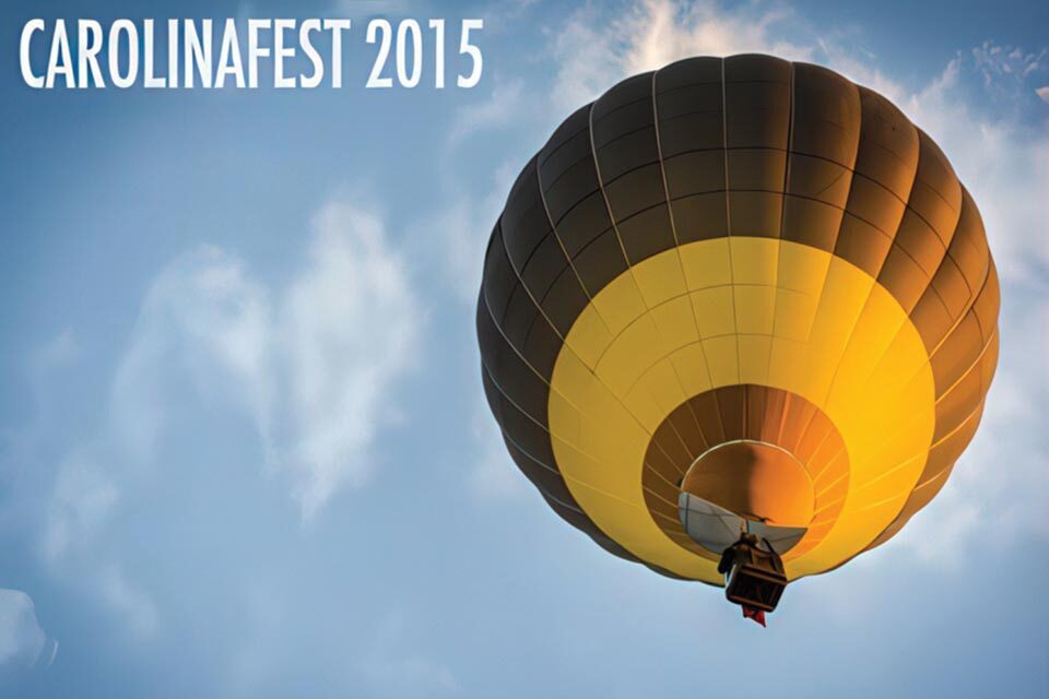 A hot air balloon with a yellow and brown design floats against a blue sky with wispy clouds. The text "CAROLINAFEST 2015" is in the top left corner.