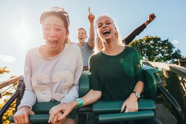 girls about to experience stomach drop on roller coaster ride