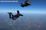 Two skydivers free-falling with parachute gear in a clear blue sky over a vast, green landscape. The text "End of Summer Special" is in the top left corner.