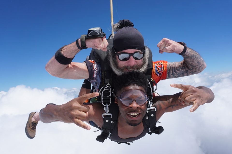 tandem-skydiving-video-trent-and-student-flexing