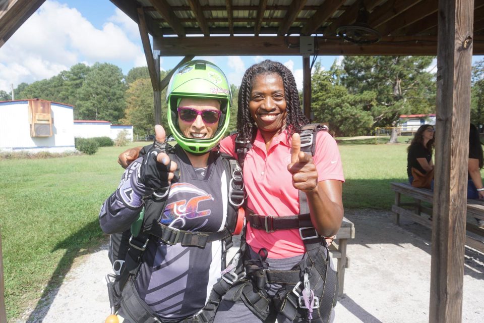 about-tandem-student-and-cathy-pointing-at-camera-smiling-skydive-carolina